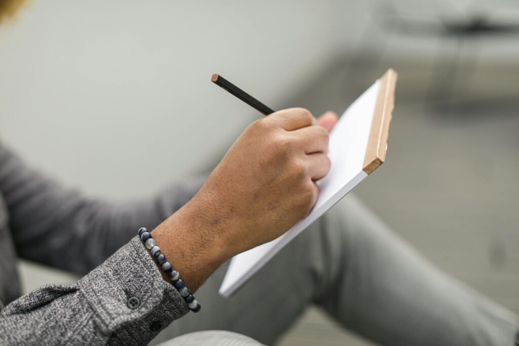 person writing in journal park