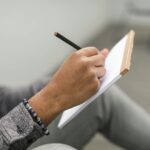 person writing in journal