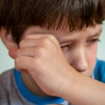 child looking sad adult hand reaching