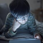 child using tablet with parent looking