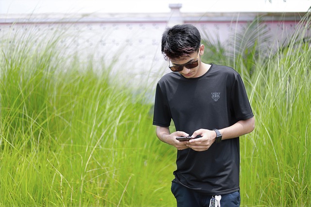 Person mindfully using a smartphone, with nature and a book nearby, symbolizing digital balance