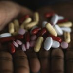 person overwhelmed by pills
