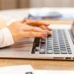 woman writing at laptop lifestyle blog